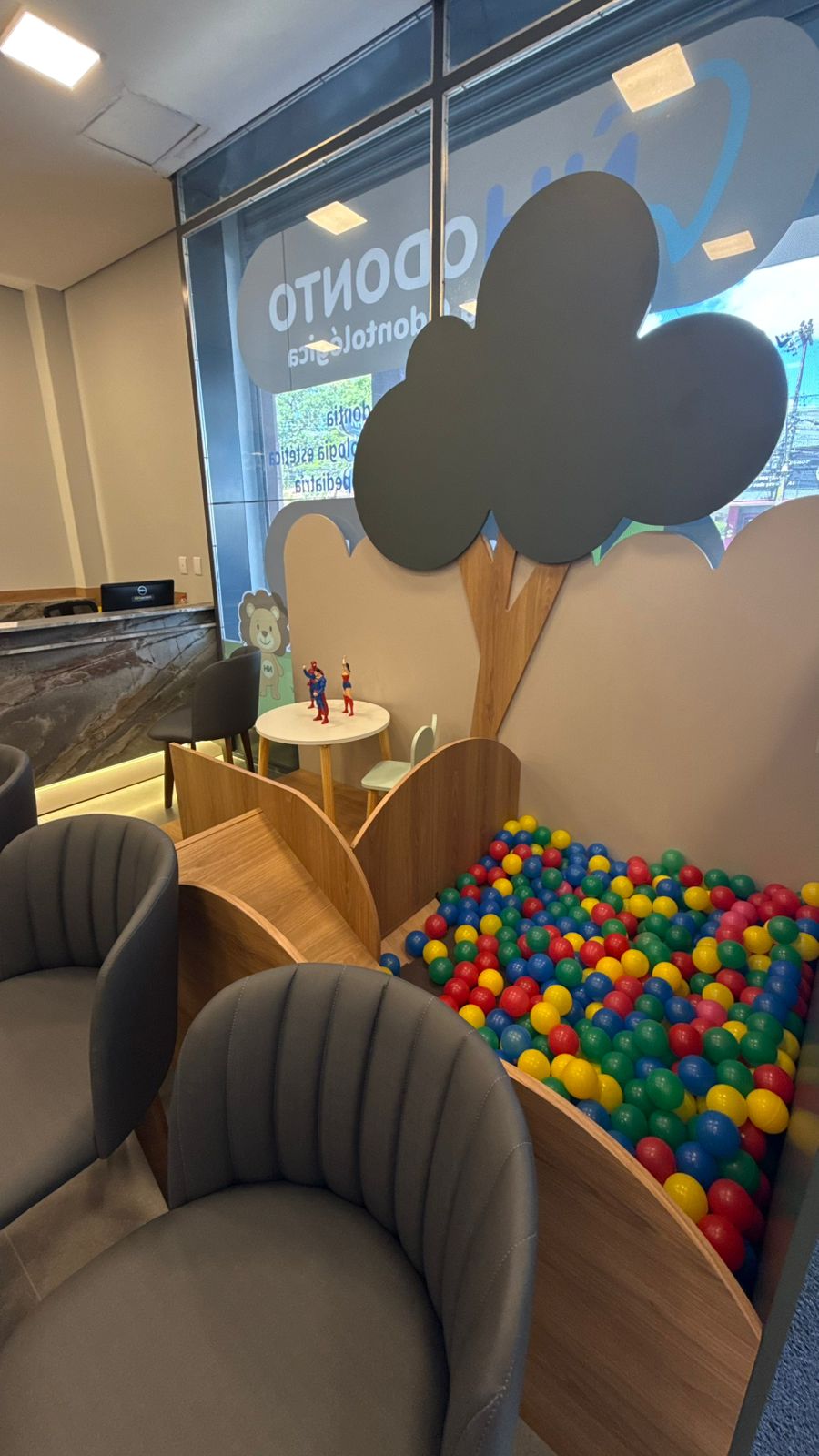 Brinquedoteca com piscina de bolinhas coloridas e árvore decorativa