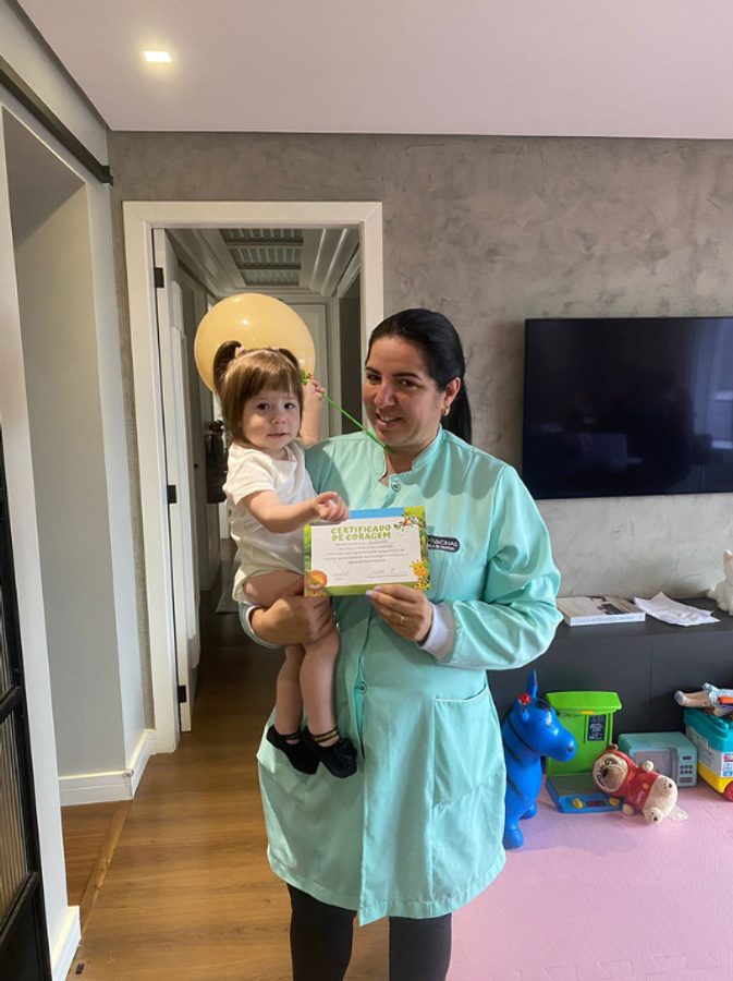 Enfermeira da NH Vacinas em atendimento domiciliar com bebê e certificado de vacinação